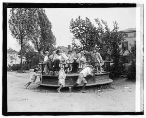 Children on a small go-round in a playground sometime around 1920. 