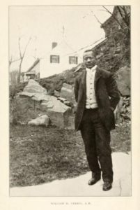 Photo of William H. Ferris standing in rocky New England landscape.